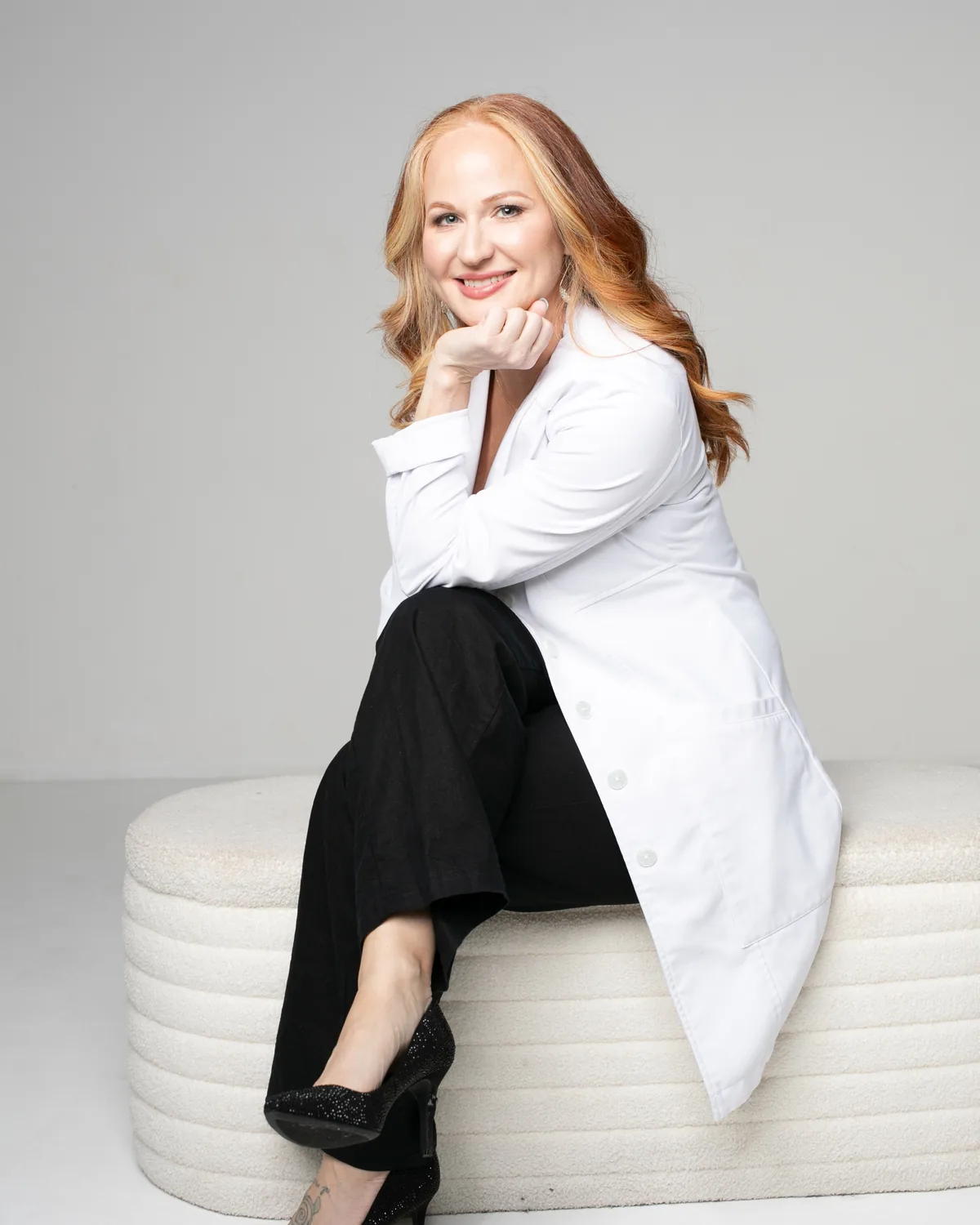 Jamie Lobacz, APRN, seated in a white coat and smiling toward the camera.
