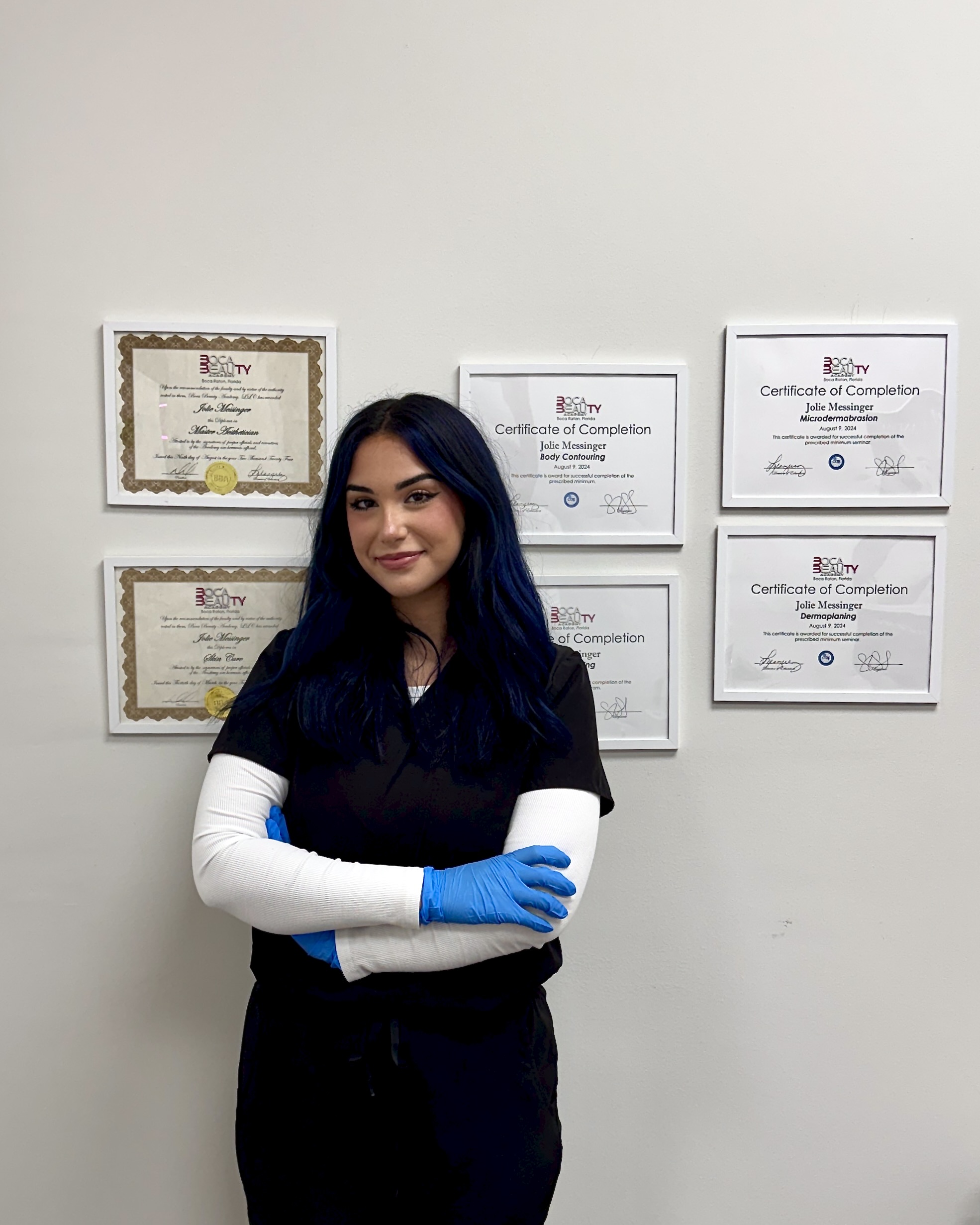 Jolie Messinger, master esthetician at The Ginger Injector, Boca Raton, in front of her framed training certificates